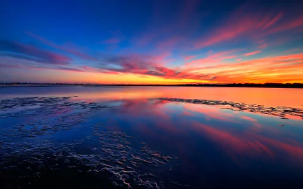 HD PC desktop wallpaper showing a serene lake at sunset with vibrant pink, orange, and blue hues reflecting on the water under a dramatic sky.