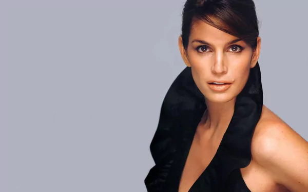 HD desktop wallpaper featuring celebrity Cindy Crawford against a simple gray background, showcasing her striking pose and elegant black outfit.