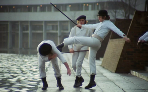 HD desktop wallpaper from the movie A Clockwork Orange, featuring characters dressed in white performing a dynamic dance near a waterfront.
