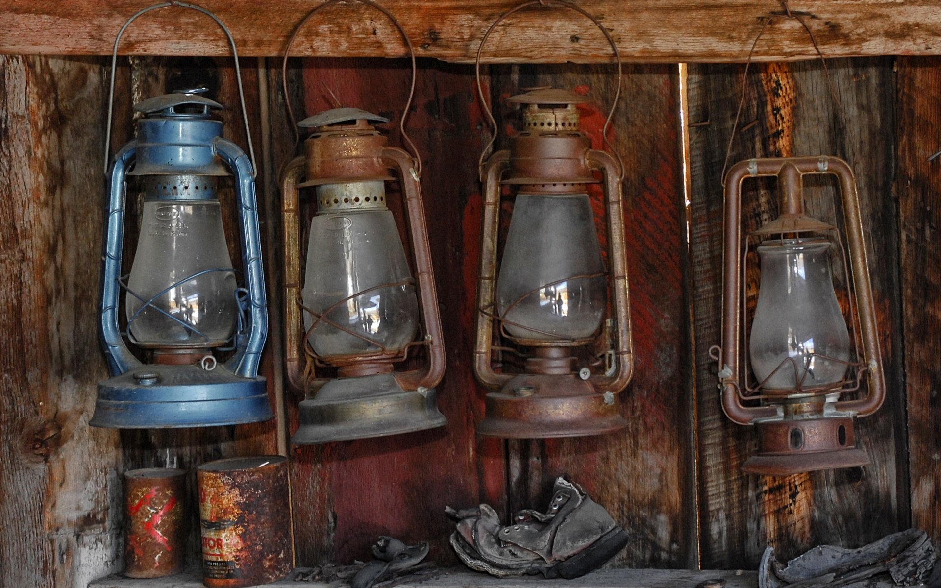 HD desktop wallpaper featuring a row of old man-made lanterns hanging on a rustic wooden wall, showcasing vintage lamps with weathered textures and muted colors.