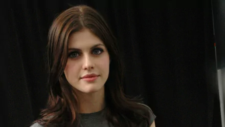 HD desktop wallpaper featuring Alexandra Daddario against a dark background, wearing a casual grey top with a serene expression.
