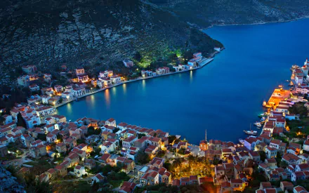 A man-made coastal village illuminated at dusk on Kastellorizo, captured in a vibrant HD desktop wallpaper.