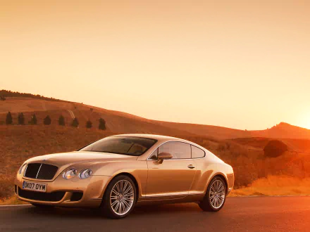HD desktop wallpaper showcasing a Bentley Continental GT Speed parked on a scenic, sunlit landscape with rolling hills in the background.