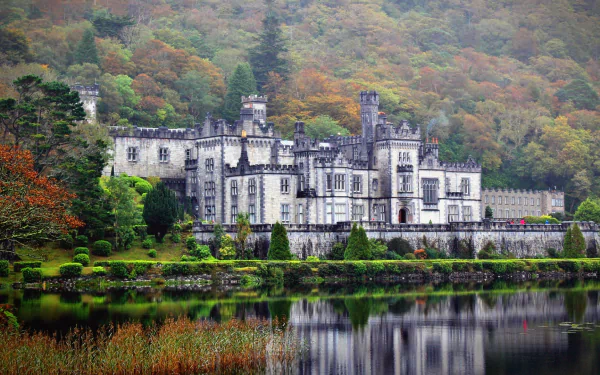 HD desktop wallpaper of Kylemore Abbey, a historic religious site surrounded by lush greenery and reflected in a calm lake.