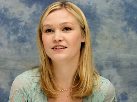 A close-up of celebrity Julia Stiles, showcasing her blonde hair and soft smile against a blue textured background, captured in HD for a desktop wallpaper.