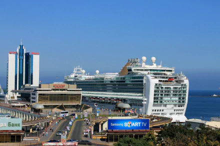 Man-made structures in Odessa featuring a large cruise ship docked at a busy port with modern buildings under a clear blue sky, captured in HD for a desktop wallpaper.