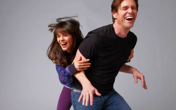 HD wallpaper featuring a joyful scene with the actors from Yes Man having fun, with Jim Carrey giving Zooey Deschanel a piggyback ride.