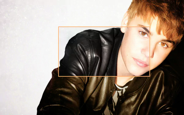 HD desktop wallpaper featuring music artist Justin Bieber in a stylish black leather jacket, leaning against a white background.