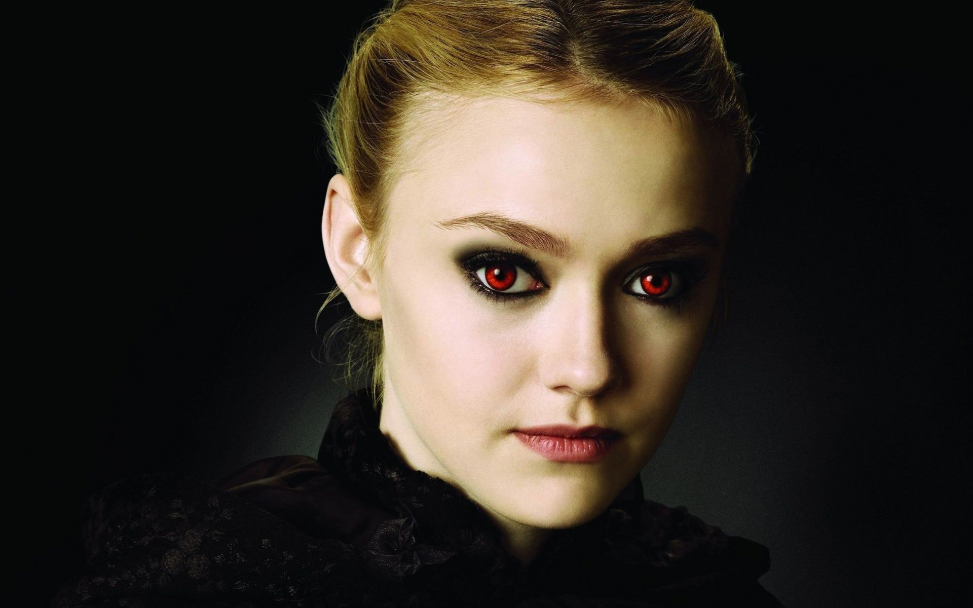 A striking HD desktop wallpaper featuring American actress Dakota Fanning, showcasing her intense gaze with dramatic makeup and a dark backdrop.