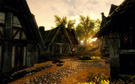 HD PC desktop wallpaper from the video game The Elder Scrolls V: Skyrim, depicting a sunlit village street with stone paths and medieval-style houses.