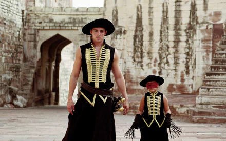 HD PC desktop wallpaper from the movie The Fall featuring Lee Pace and Catinca Untaru as their characters Alexandria and Roy Walker in matching black and gold costumes.