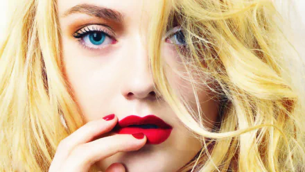 A striking HD wallpaper featuring Dakota Fanning, an American actress, showcasing her captivating blue eyes and bold red lips against a backdrop of flowing blonde hair.