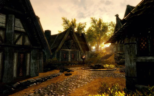 HD PC desktop wallpaper from the video game The Elder Scrolls V: Skyrim, depicting a sunlit village street with stone paths and medieval-style houses.