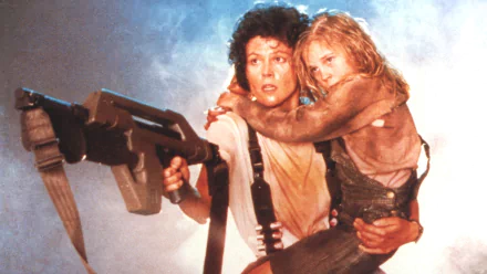 HD PC desktop wallpaper featuring a tense scene from the movie Alien, with Ripley holding a weapon and protecting a young girl amidst a smoky background.