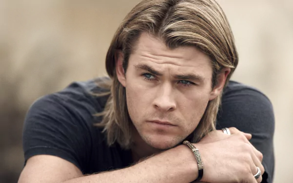 HD desktop wallpaper featuring Australian actor and celebrity Chris Hemsworth with a contemplative expression and long hair.