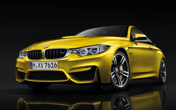 HD PC desktop wallpaper featuring a sleek yellow BMW M4 Coupe against a black background, highlighting its sporty design and dynamic presence.