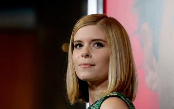 HD desktop wallpaper featuring American actress Kate Mara with a soft smile and blonde bob hairstyle against a blurred backdrop.