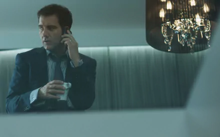 2K Quad HD desktop wallpaper: English actor and celebrity in a suit, on the phone, holding a drink beneath a hanging chandelier.