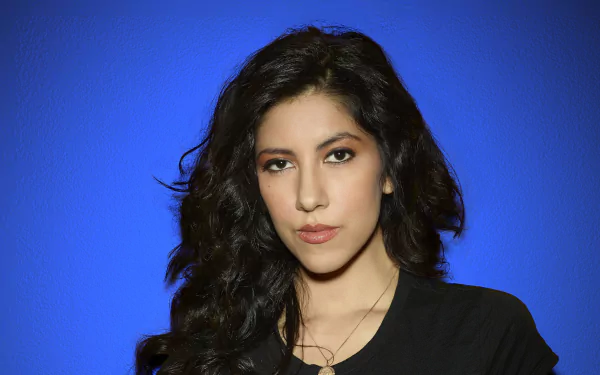 HD desktop wallpaper featuring a portrait of a woman against a blue background, tagged with Stephanie Beatriz.