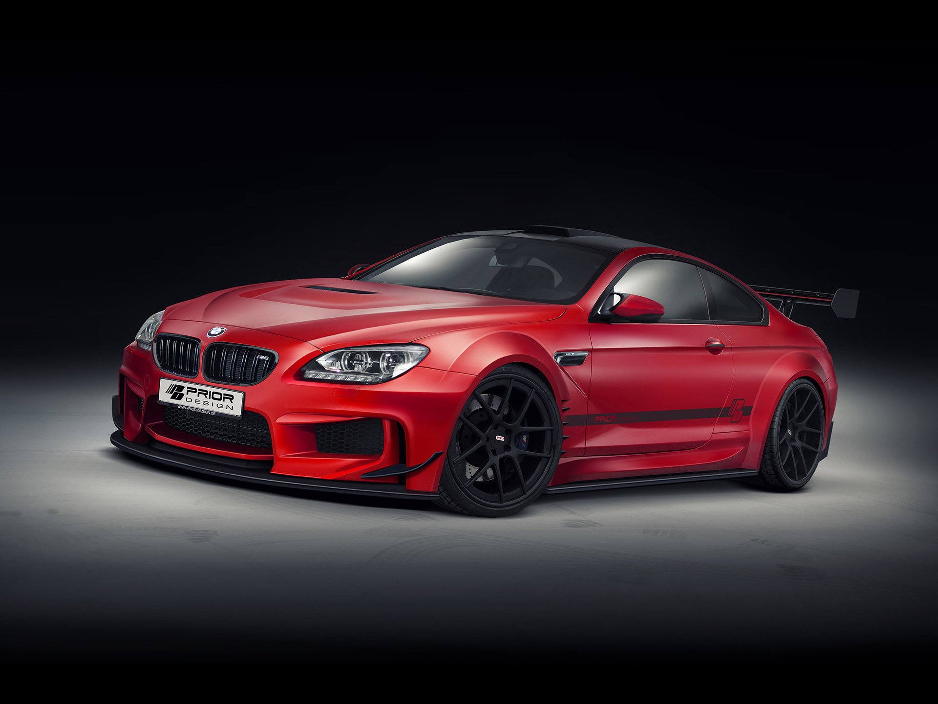 HD desktop wallpaper featuring a red Prior Design BMW M6 with sleek lines and black wheels against a dark background.