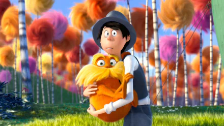 HD PC desktop wallpaper of the Once-ler from the movie The Lorax hugging the orange mustached Lorax among colorful Truffula trees.
