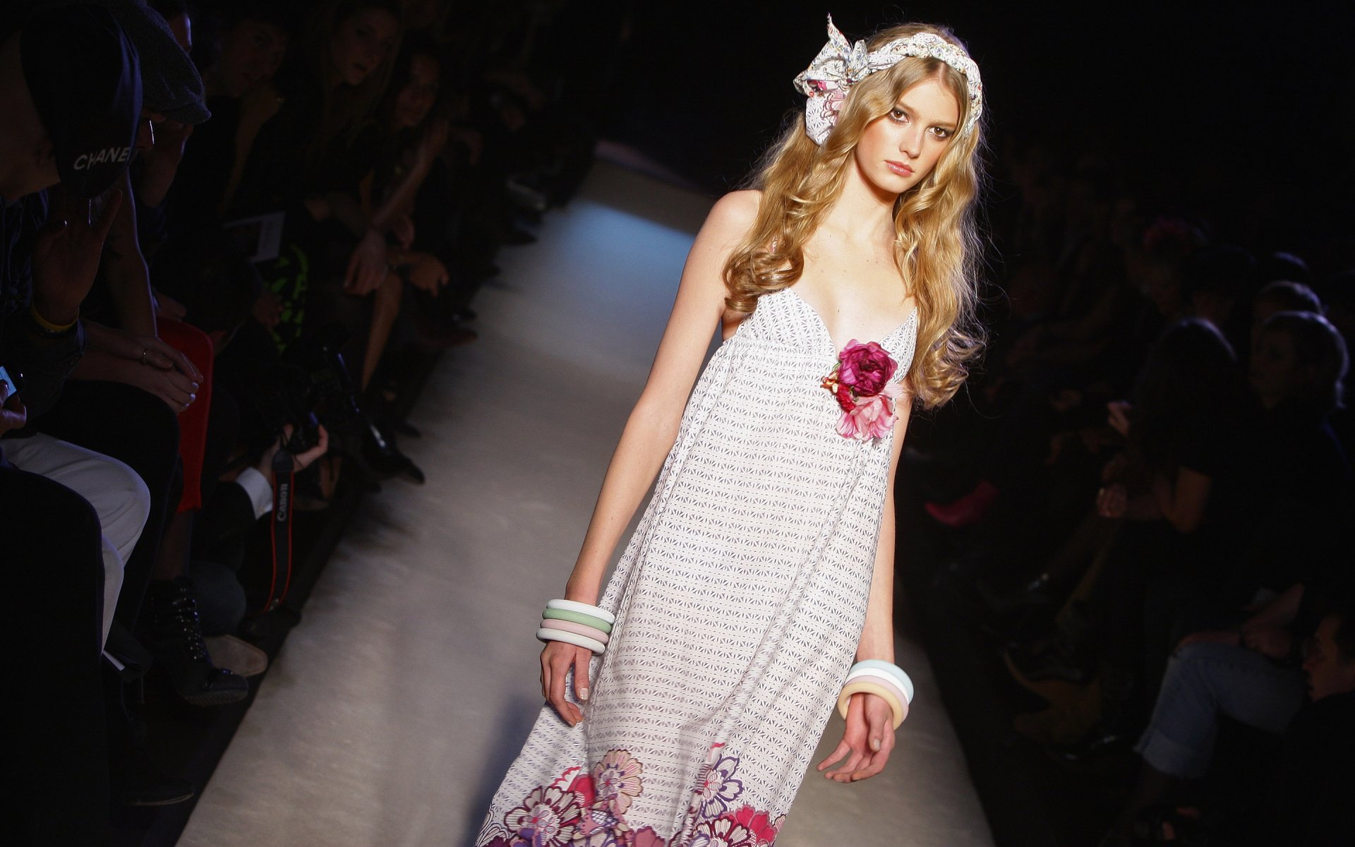 HD desktop wallpaper featuring French model Sigrid Agren walking the runway in a white dress adorned with pink floral details.