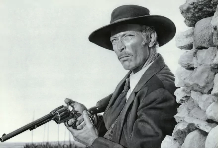 Black-and-white 4K Ultra HD desktop wallpaper depicting a scene from the movie For A Few Dollars More, featuring a man in a hat aiming a rifle.