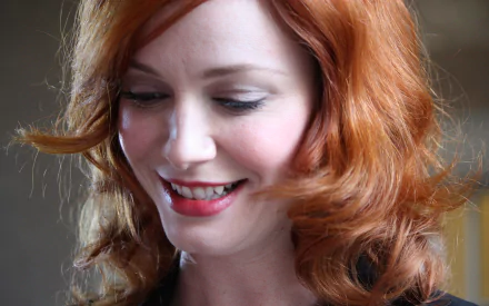 Close-up HD desktop wallpaper of American actress and celebrity Christina Hendricks, showcasing her red hair and radiant smile.