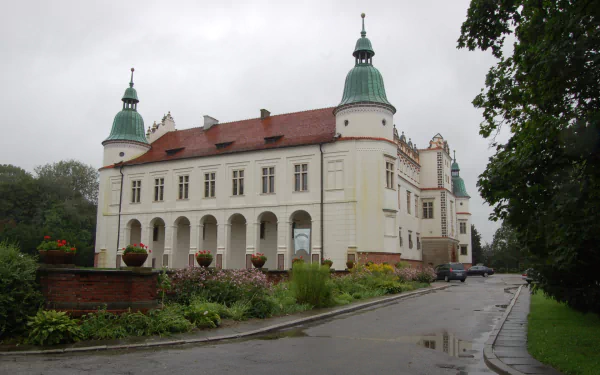 HD desktop wallpaper featuring the historic Baranów Sandomierski Castle, a man-made architectural landmark with distinctive towers and a red roof under a cloudy sky.