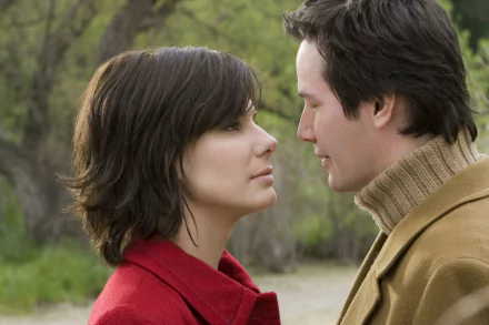 HD desktop wallpaper featuring Sandra Bullock and Keanu Reeves from the movie The Lake House, captured in a close, intimate moment outdoors.