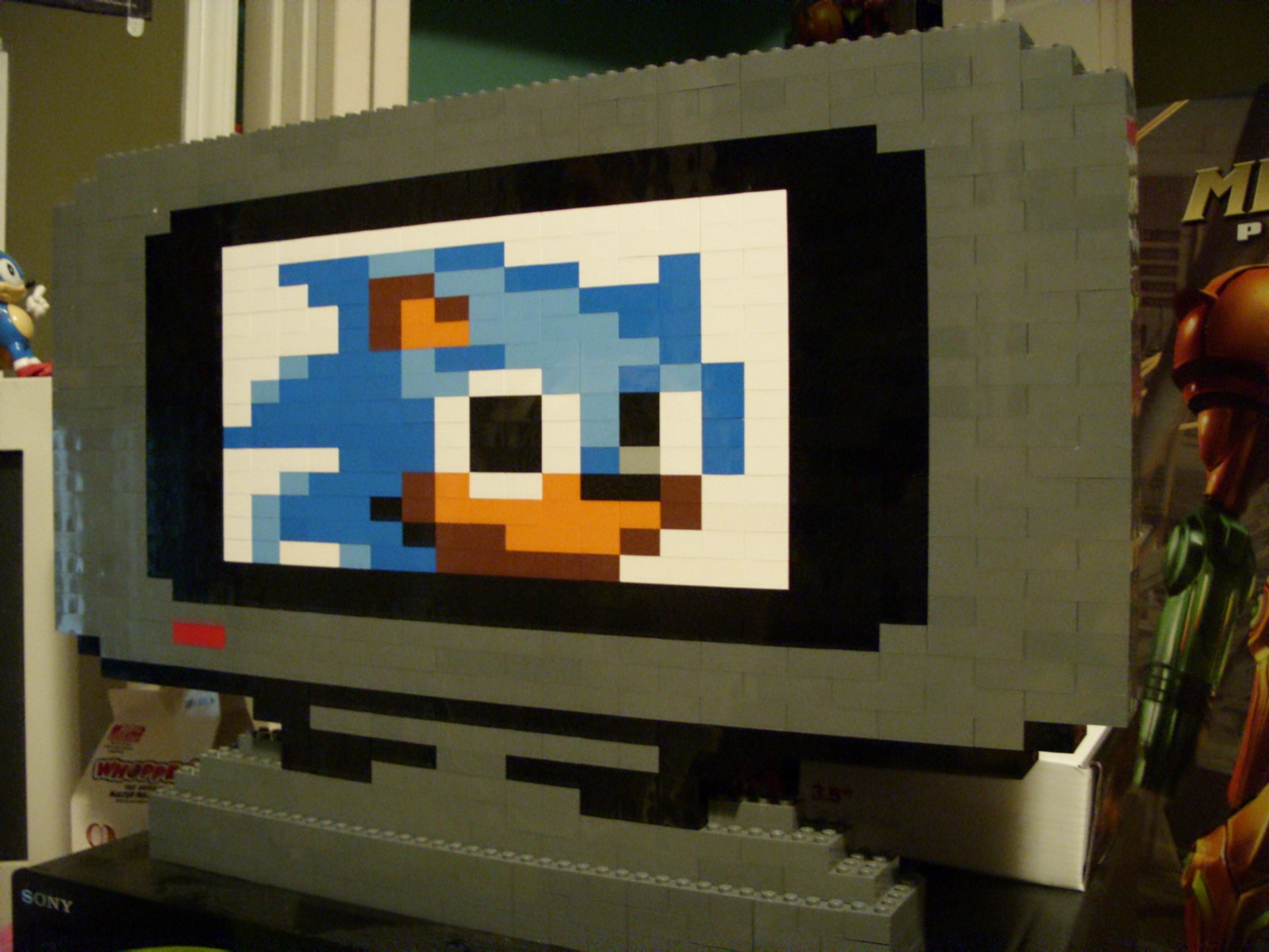 HD PC desktop wallpaper featuring a man-made LEGO sculpture of Sonic the Hedgehog displayed on a blocky screen.