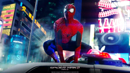 HD desktop wallpaper of Spider-Man from The Amazing Spider-Man 2 movie, posed atop a police car with brightly lit cityscape in the background.
