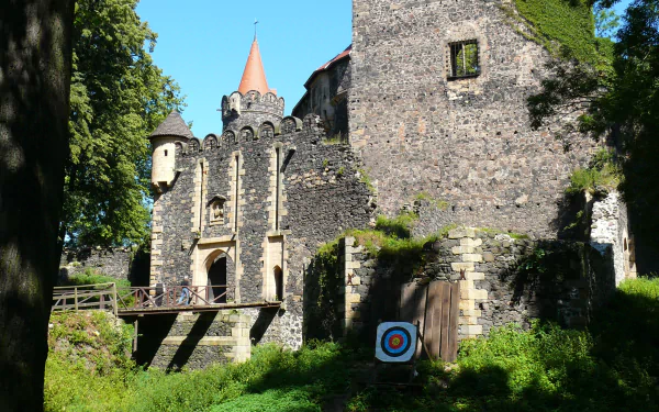 Sunlit Grodziec Castle, a man-made stone fortress with arched gateway and ivy-clad walls, 2K Quad HD PC desktop wallpaper/background.