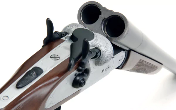 A close-up of a beautifully crafted double-barrel shotgun, showcasing intricate details of the wood and metalwork, set against a clean background for an HD desktop wallpaper.