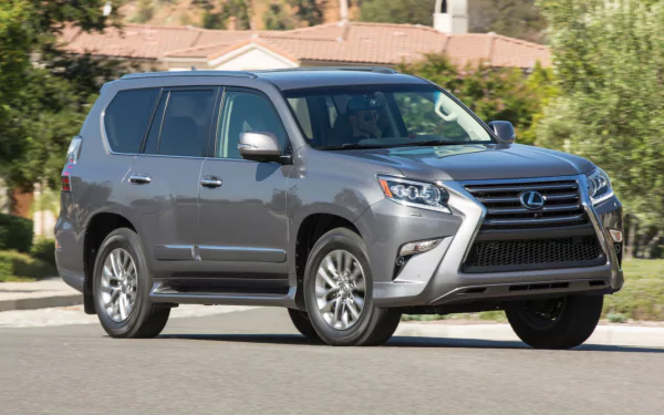 HD PC desktop wallpaper of a silver Lexus GX SUV parked on a suburban street, with houses and trees in the background.