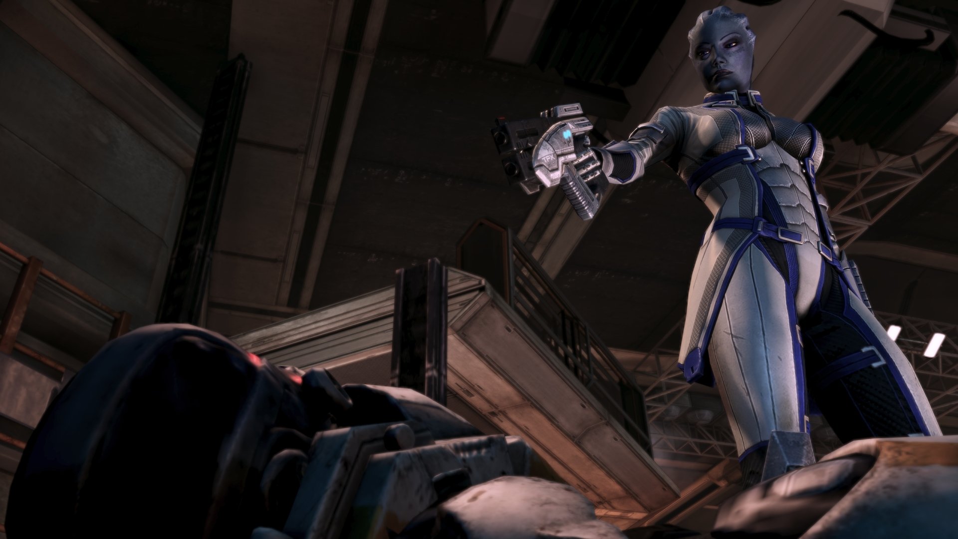 HD PC desktop wallpaper featuring Liara T'Soni from the Mass Effect video game, showcasing her in a commanding pose holding a weapon in a dimly lit industrial setting.