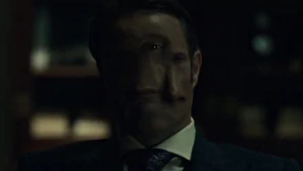 HD desktop wallpaper featuring a dark, eerie close-up of a character from the TV show Hannibal, blending shadow and light for a haunting visual effect.