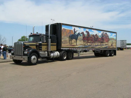 HD PC desktop wallpaper showing a black Peterbilt semi with a western stagecoach mural on its trailer, referencing the movie Smokey and the Bandit.