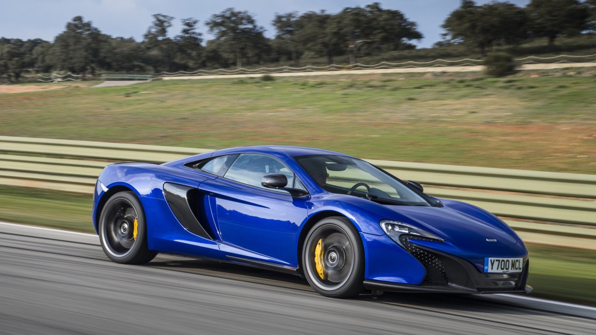 Blue McLaren 650S supercar racing on a track, high-performance car depicted as an HD PC desktop wallpaper/background.