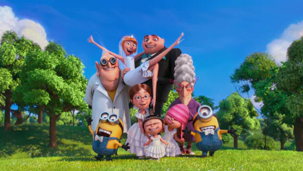 A vibrant HD wallpaper featuring characters from Despicable Me 2: Lucy, Margo, Edith, Agnes, Dr. Nefario, Gru, and Minions, smiling together in a lush green setting.
