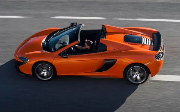 Orange McLaren 650S Spider supercar captured in motion on a racetrack, showcased as an HD PC desktop wallpaper and background.