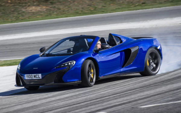 Blue McLaren 650S Spider supercar speeding on a racetrack, captured in high definition as a striking PC desktop wallpaper and background.