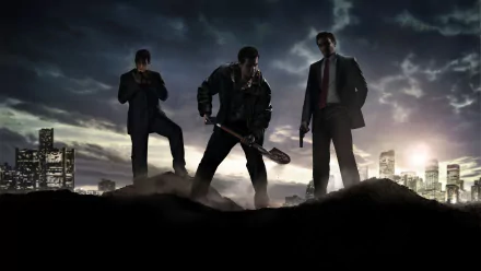 HD wallpaper featuring a scene from the video game Mafia II, depicting three men in dark outfits standing on a mound of dirt with a city skyline in the background at dusk.
