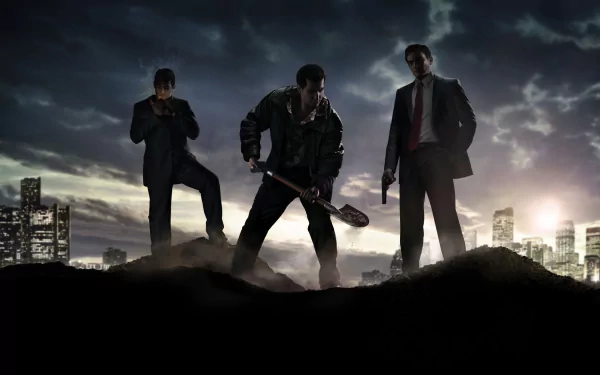 HD wallpaper featuring a scene from the video game Mafia II, depicting three men in dark outfits standing on a mound of dirt with a city skyline in the background at dusk.
