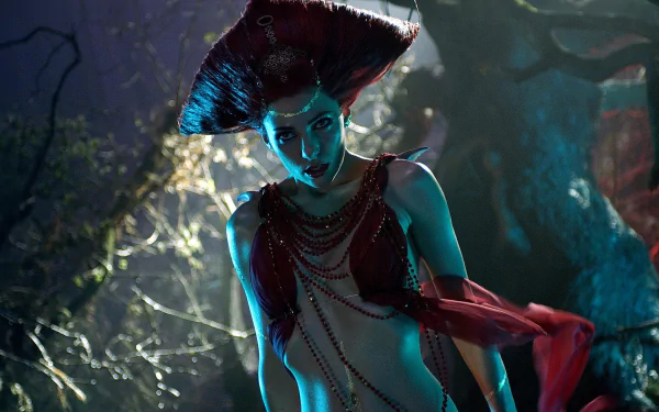Blue-green lit vampire woman in ornate headdress and draped chains in a moonlit forest — cinematic still from the movie Lesbian Vampire Killers, HD PC desktop wallpaper/background.