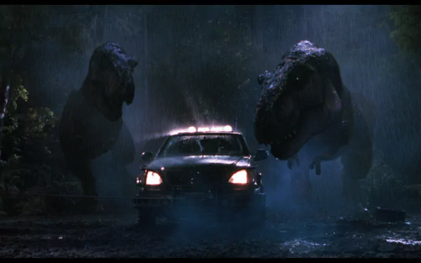 HD desktop wallpaper from the movie The Lost World: Jurassic Park, featuring two roaring T-Rex dinosaurs confronting a truck in a dark, foggy forest setting.