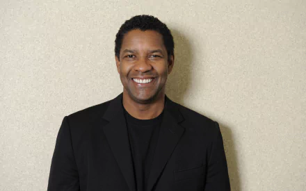 HD desktop wallpaper featuring American actor and celebrity Denzel Washington smiling in a black blazer against a plain light background.