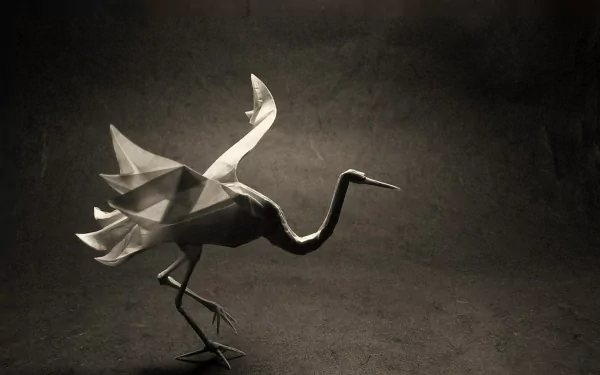 A beautifully crafted origami bird stands gracefully, showcasing intricate folds and details against a dark background, making it a striking HD desktop wallpaper.