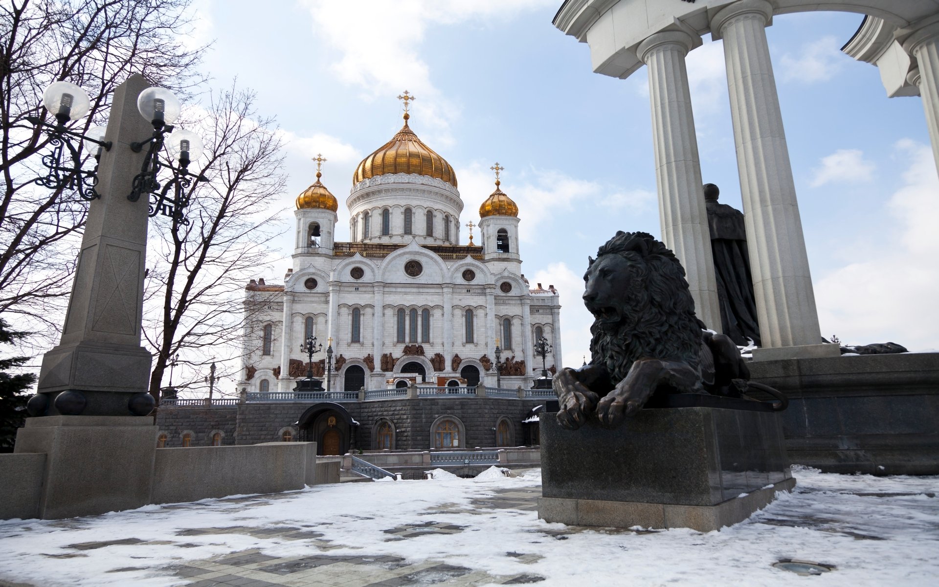 Religious view of the Cathedral of Christ the Saviour with golden domes and a foreground lion statue on a snowy square — HD PC desktop wallpaper/background.