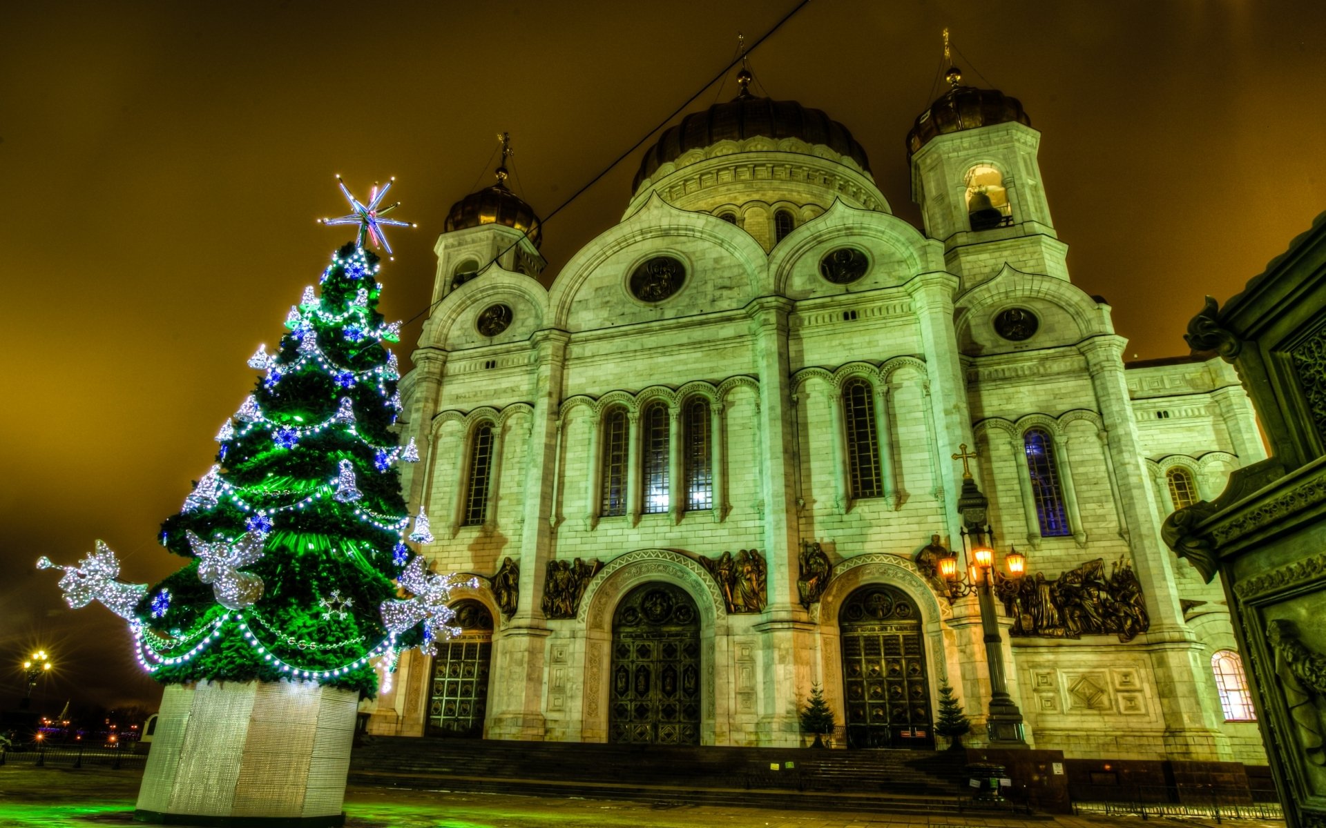 Religious scene of the Cathedral of Christ the Saviour glowing at night beside a decorated Christmas tree — HD PC desktop wallpaper/background.